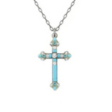 The Simple Cross Ice Necklace from Firefly features a silver chain with a cross pendant adorned with turquoise stones and sparkling clear gemstones at the center and ends, making it a striking handmade piece from Firefly Jewelry.