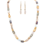 The A-Train Gold Pink Fire Polish Faceted Beads Necklace Set includes matching dangle earrings with soft neutral tones and gold accents, elegantly presented on a white background for a refined touch to any outfit.