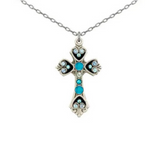 A Moonlight Medium Cross Light Blue (Hearts) Necklace from Firefly is displayed on a white background, featuring a silver cross pendant adorned with light blue and clear gemstones on a fine chain. This elegant piece showcases intricate design inspired by Firefly Jewelry and reflects the artisan craftsmanship of handmade Guatemalan necklaces.