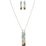 The A-Train Silver Blue Wash Dragonfly Necklace Set includes a necklace and matching earrings with rectangular pendants in abstract teal, blue, yellow, and green, evoking dragonfly and landscape designs.