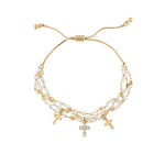 The A-Train Gold Faux Pearl Bead Cross Charm Bracelet features three cross charms and double strands of small white pearls, offering an adjustable fit and timeless style to enhance any outfit.