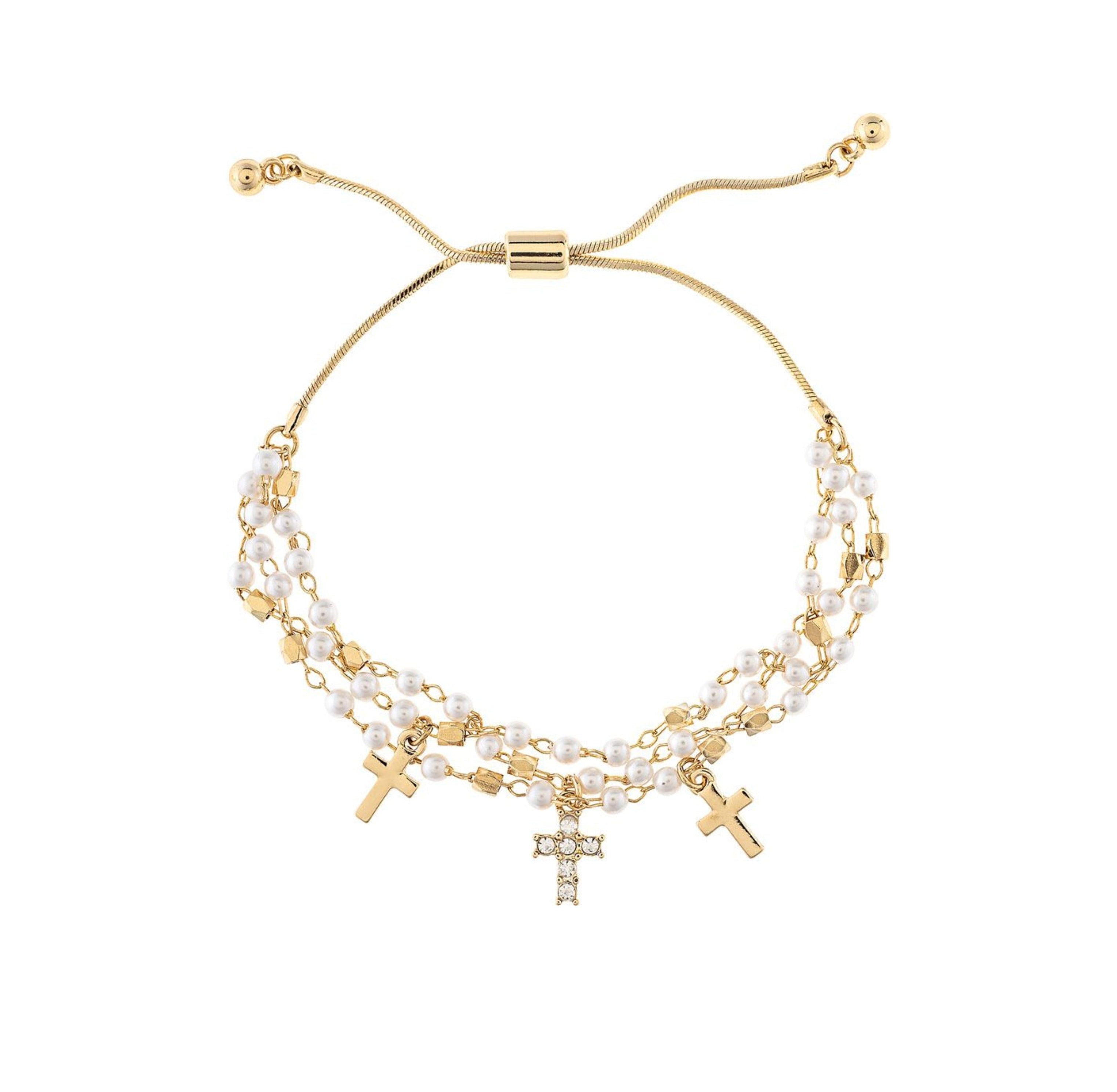 The A-Train Gold Faux Pearl Bead Cross Charm Bracelet features three cross charms and double strands of small white pearls, offering an adjustable fit and timeless style to enhance any outfit.