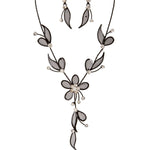 The A-Train Mesh Leaf Flower Black Necklace Set features black mesh and sheer petal shapes with clear crystals, creating an elegant floral design.