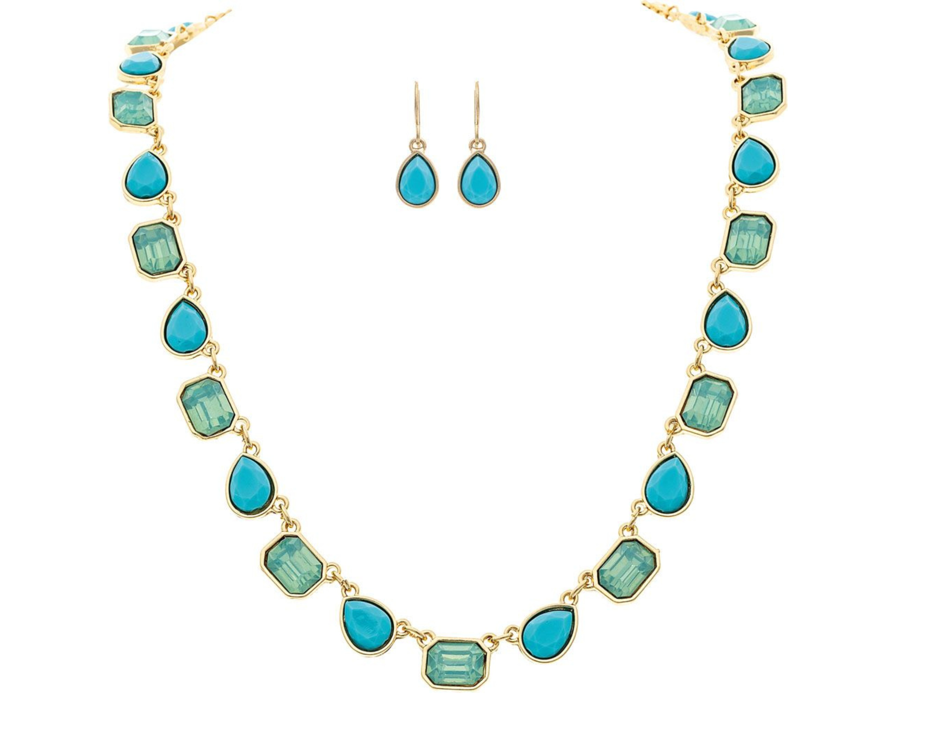 The A-Train Gold Blue Glow Gem Shapes Necklace Set features a necklace with alternating blue teardrop and rectangular stones and matching teardrop earrings, elegantly displayed on a crisp white background.