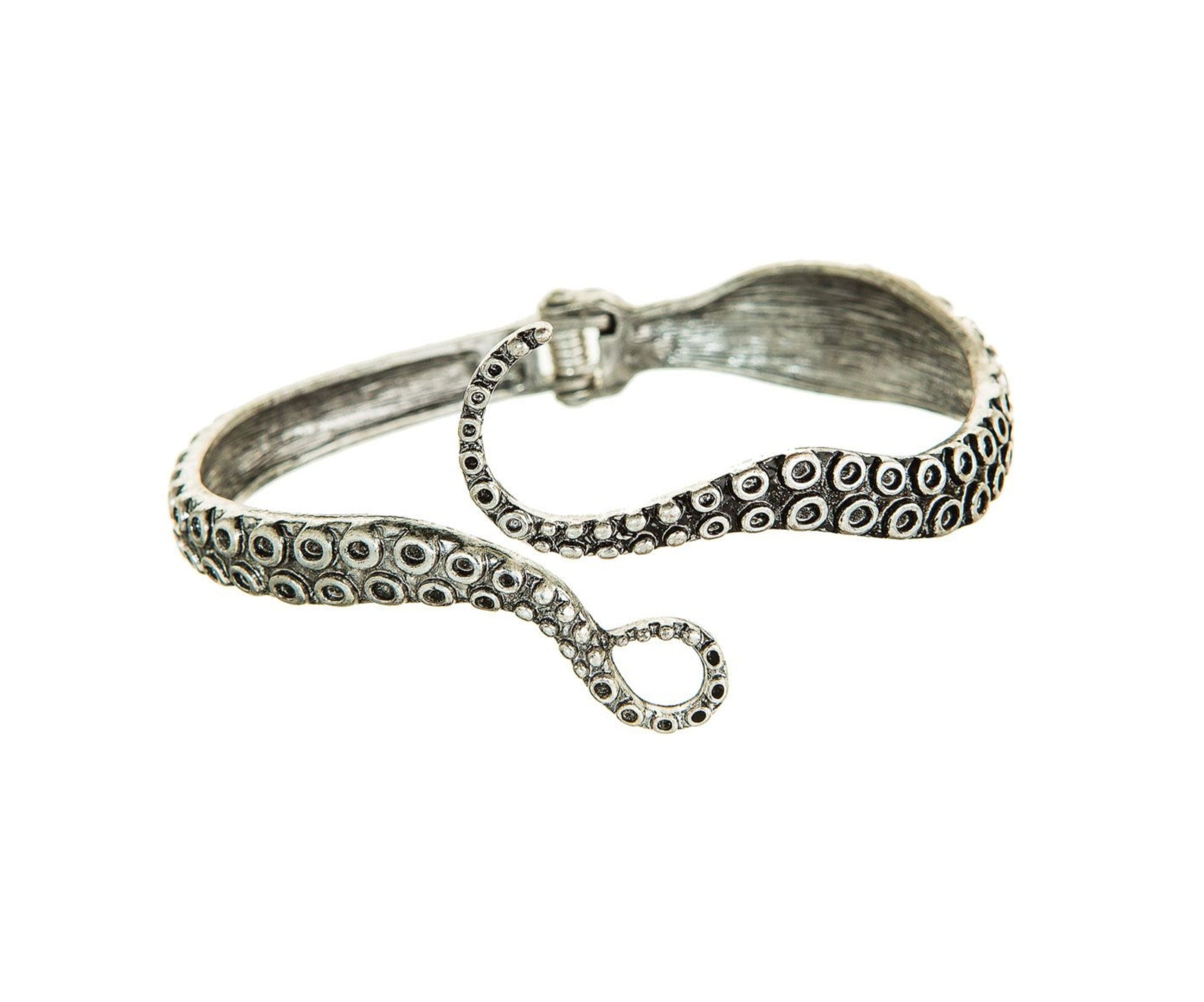 The A-Train Silver Octopus Hinge Cuff Bracelet features a detailed curled tentacle design with suction cup patterns and a secure clasp, displayed against a white background.