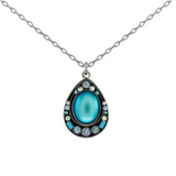Discover the Moonlight Simple Drop Wide Pendant Light Blue Necklace from Firefly—a stunning piece of handmade fair-trade jewelry. This silver chain necklace features a teardrop-shaped pendant with a vibrant light blue center, beautifully accented by small round white and blue stones.
