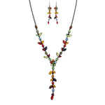The A-Train Black Multi Jewel Tone Gems Y Drop Necklace Set features a matching necklace and earrings with leaf and round-shaped gems on a dark metal chain for a vibrant, nature-inspired look.