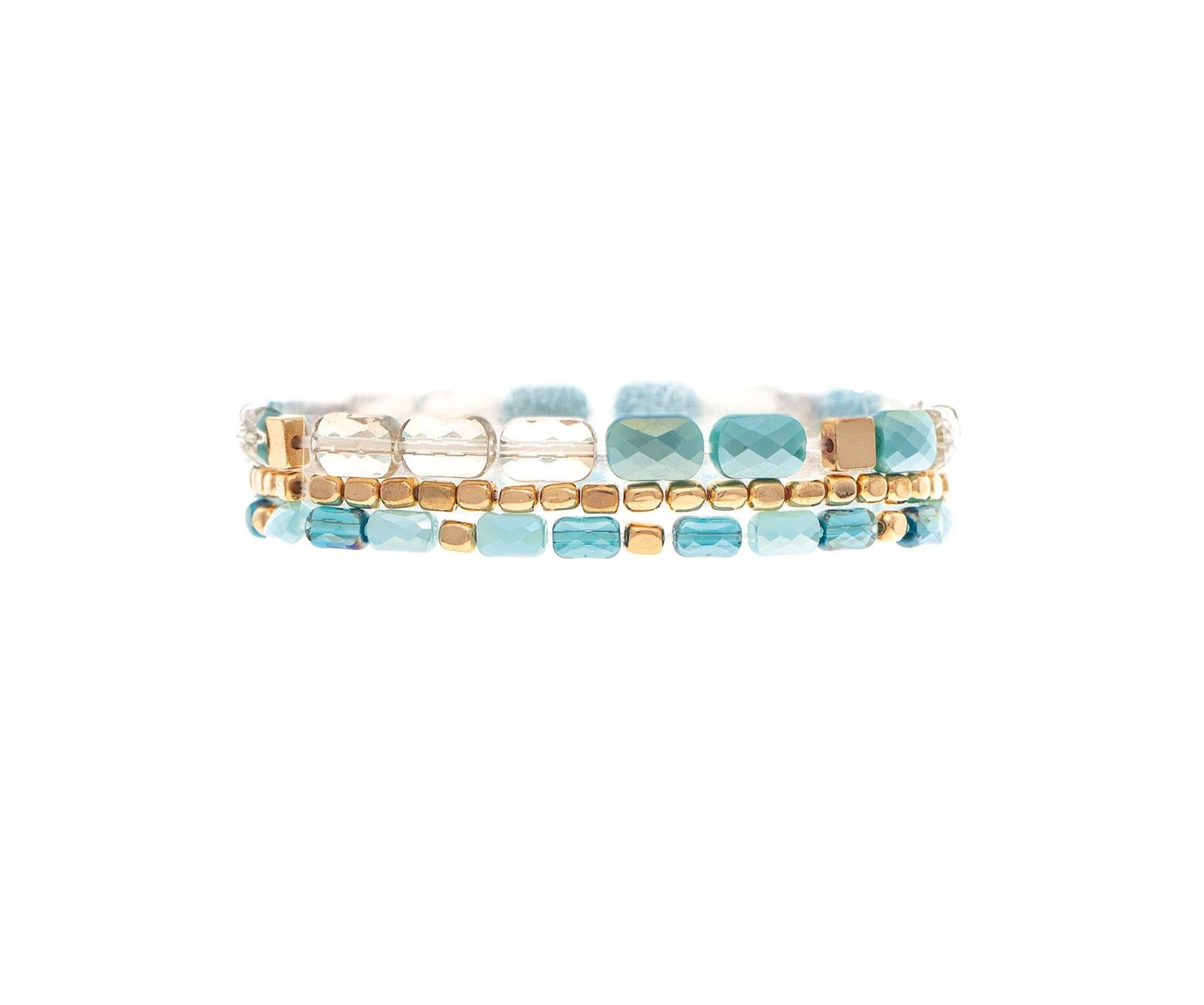 The A-Train Gold Blue Fire Polish Facet Bead 3 Piece Set Bracelet features three rows of turquoise, white, and gold square beads in a repeating pattern. This handcrafted set is elegant and versatile for any occasion.