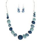 The A-Train Silver Multi-Color Blue & Aqua Wash Concave Circles Necklace Set features alternating blue and aqua concave circles with matching dangle earrings, creating a striking look against a white backdrop.