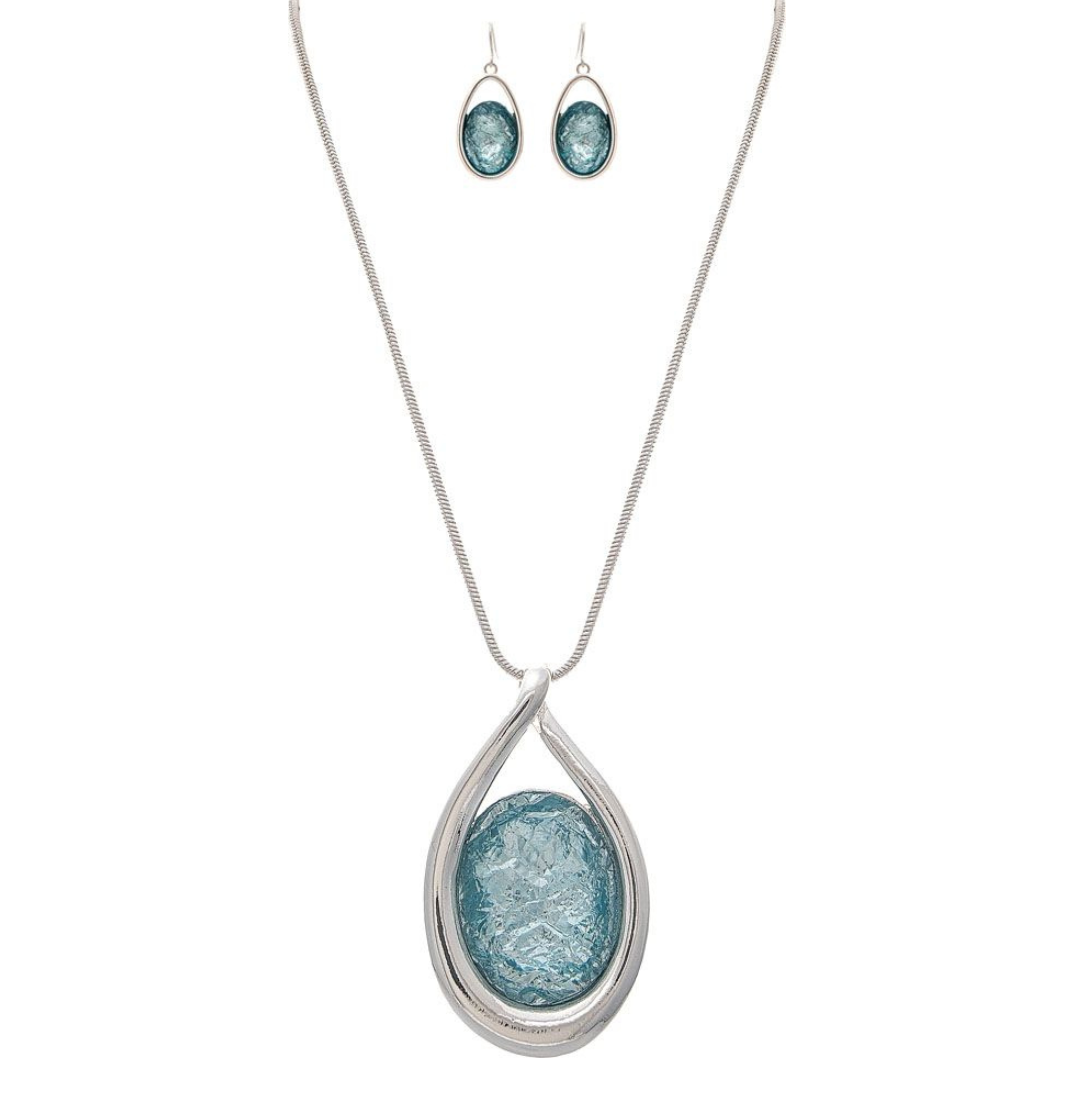 The A-Train Silver Big Blue Crystal Necklace Set features a high-quality silver chain with a large blue textured oval pendant and matching blue oval drop earrings—ideal for special occasions.