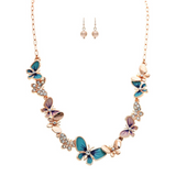 A-Train Rose Gold Crystal & Blue Butterfly Necklace Set features blue and purple butterfly charms with clear crystals, paired with round gold stud earrings—an elegant crystal jewelry set for any occasion, shown on a white background.