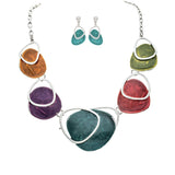The A-Train Silver Multi Paint Palette Necklace Set features a silver chain with vibrant, irregular pendants crafted from quality mixed metals, plus coordinating teal dangle earrings with silver accents.
