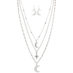 The A-Train Silver Moons & Star Layer Necklace Set includes four layered necklaces with crescent moon and star pendants, crafted from mixed jeweler’s metals, plus matching silver crescent moon dangle earrings.