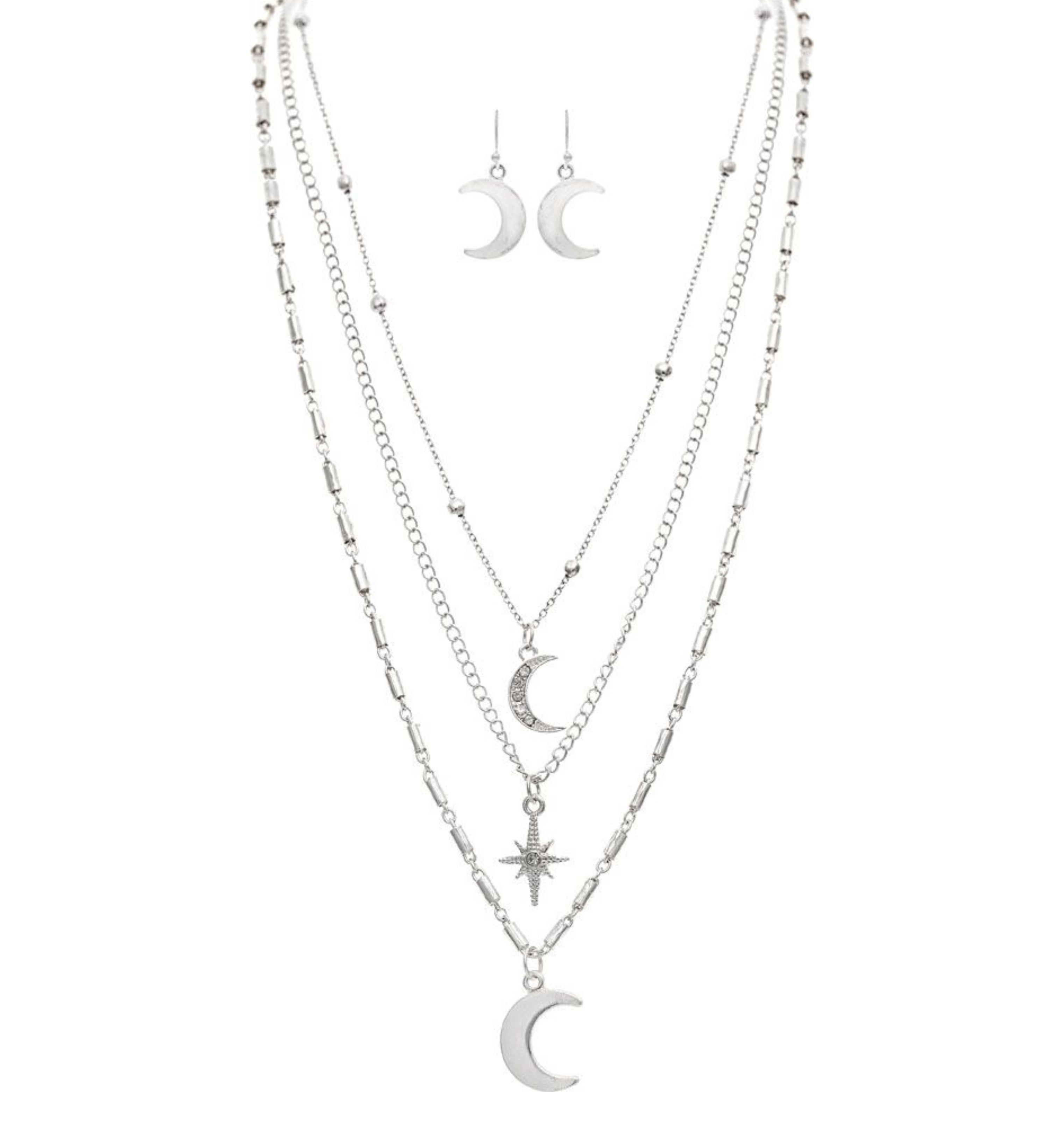 The A-Train Silver Moons & Star Layer Necklace Set includes four layered necklaces with crescent moon and star pendants, crafted from mixed jeweler’s metals, plus matching silver crescent moon dangle earrings.
