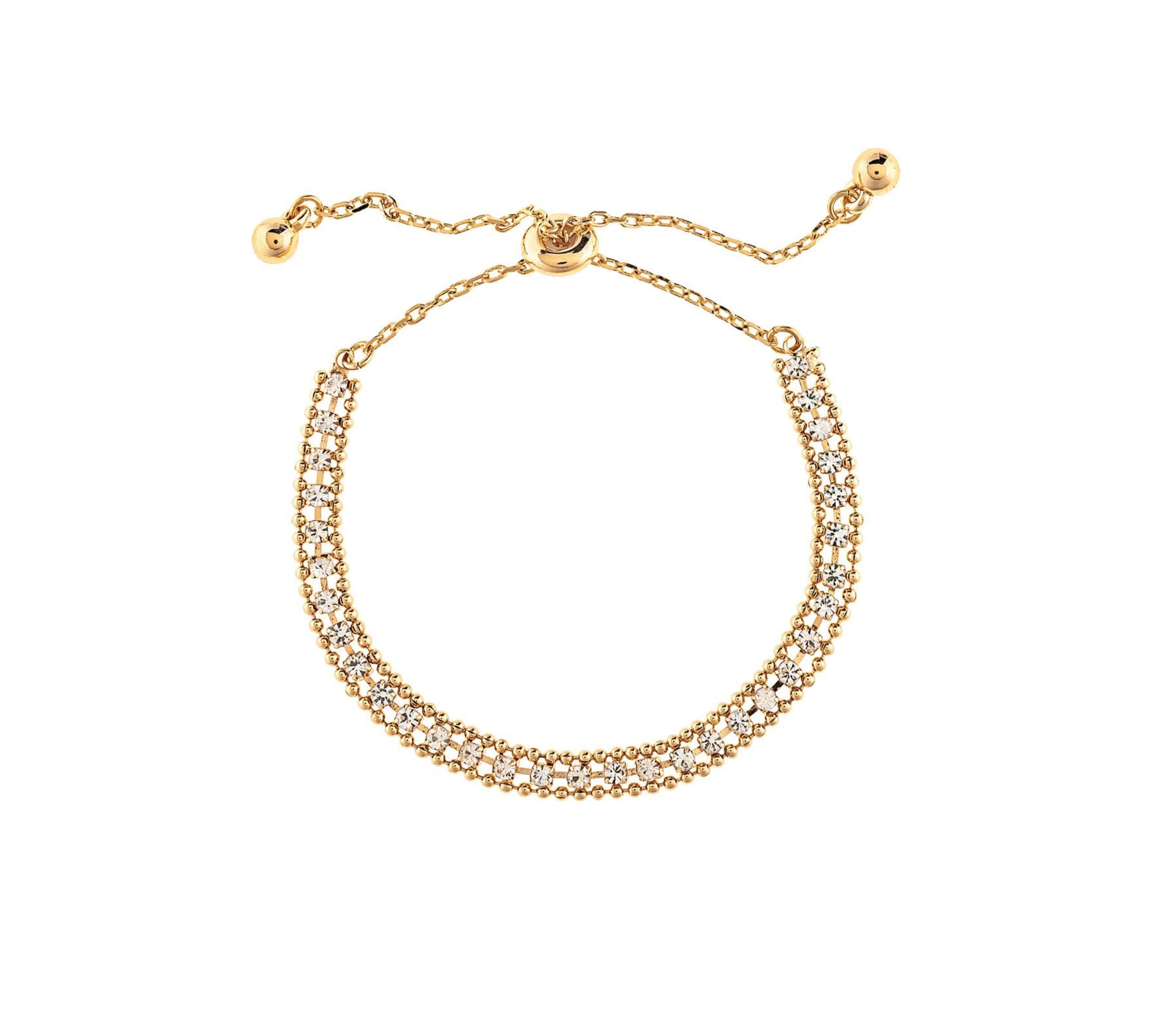The A-Train Gold Crystal Row Slide Clasp Bracelet features two rows of sparkling clear stones and an adjustable sliding clasp with gold bead ends—an elegant accessory for any occasion.