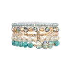 The A-Train Gold Mixed Beads Cross 5 Pc Set Bracelet includes clear, gold, and turquoise beaded bracelets plus a gold mixed beads bracelet with a rhinestone-encrusted sideways cross.