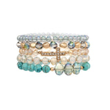 The A-Train Gold Mixed Beads Cross 5 Pc Set Bracelet includes clear, gold, and turquoise beaded bracelets plus a gold mixed beads bracelet with a rhinestone-encrusted sideways cross.