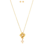 The A-Train Gold Love Knot w/ Freshwater Pearl Necklace Set features a knot pendant necklace with a freshwater pearl and matching round pearl stud earrings, elegantly displayed on a white background.