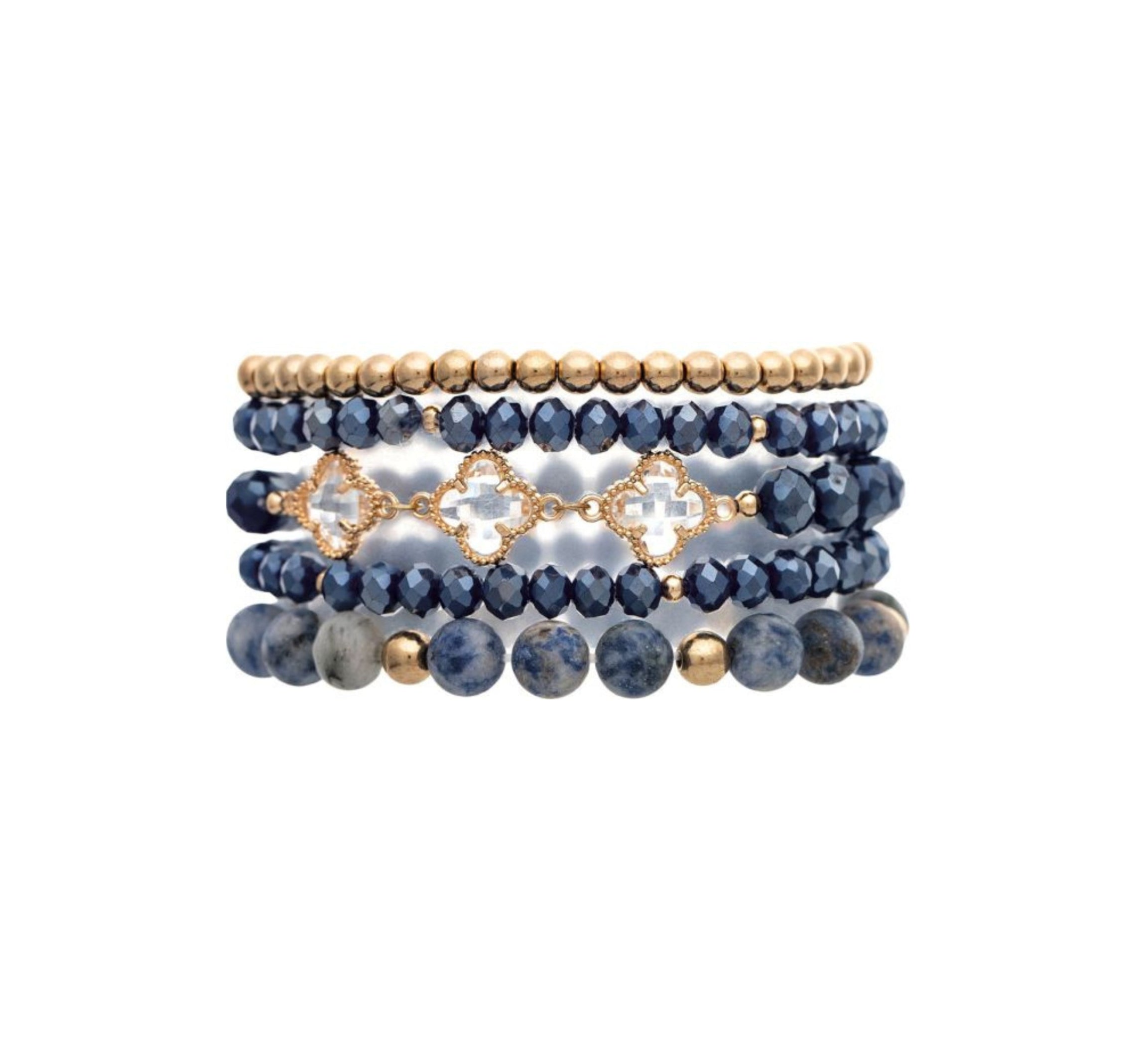 The A-Train Gold Mix Bead Sodalite Clovers 5 Pc Set Bracelet features five flexible bracelets with alternating gold and dark blue beads, including faceted blue beads and gold quatrefoil accents.