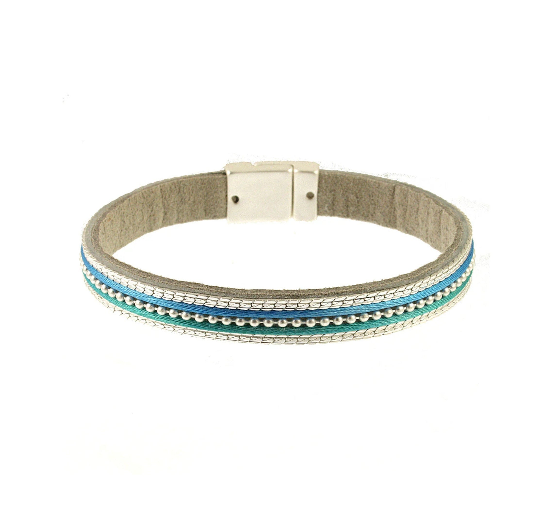 The Origin Matte Silver, Blue & Aqua Bead Center Magnetic Bracelet features elegant silver, turquoise, and blue beads in parallel rows with a silver clasp—an eye-catching accessory for any occasion.