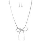 The A-Train Silver Herringbone Chain Bow Tie Necklace Set features a silver bow pendant and matching drop earrings with round beads, elegantly displayed on a white background.