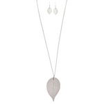 The A-Train Silver Long Large Natural Leaf Necklace Set features a detailed leaf-shaped pendant on a long necklace, with matching earrings, crafted from high-quality mixed metals and shown on a white background.