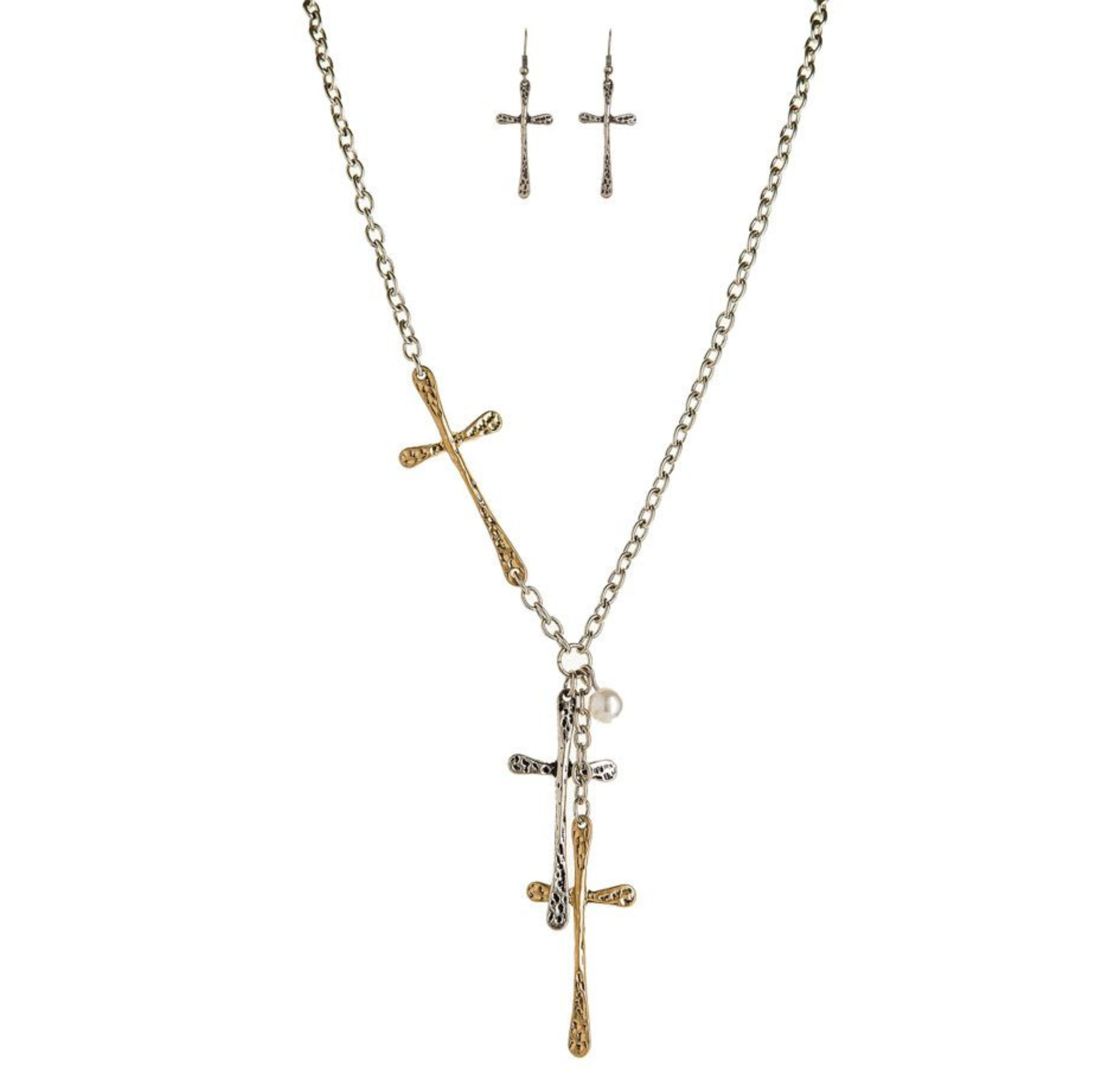 The Two-Toned Hammered Cross Necklace Set by A-Train showcases overlapping gold and silver textured crosses, paired with matching dangle earrings for a bold look.