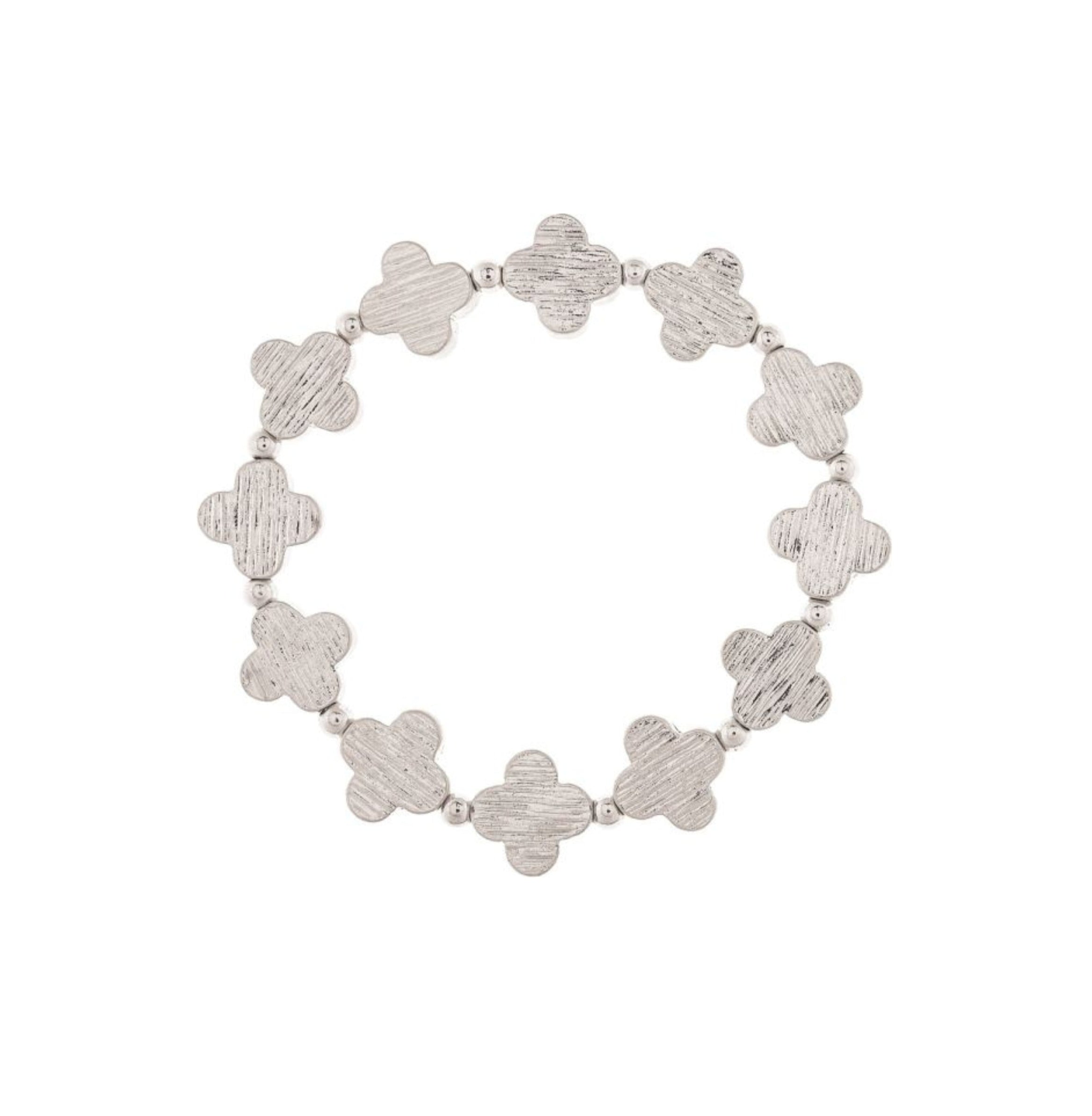 The A-Train Silver Line Etched Clovers Stretch Bracelet showcases textured four-petal links and small beads, crafted from premium mixed jeweler’s metals in a charming circular design.