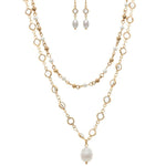 The A-Train Gold Mix Faux Pearl Crystal Necklace Set includes a layered gold-tone necklace with a large pearl pendant and matching drop earrings detailed with white pearls and small crystals.