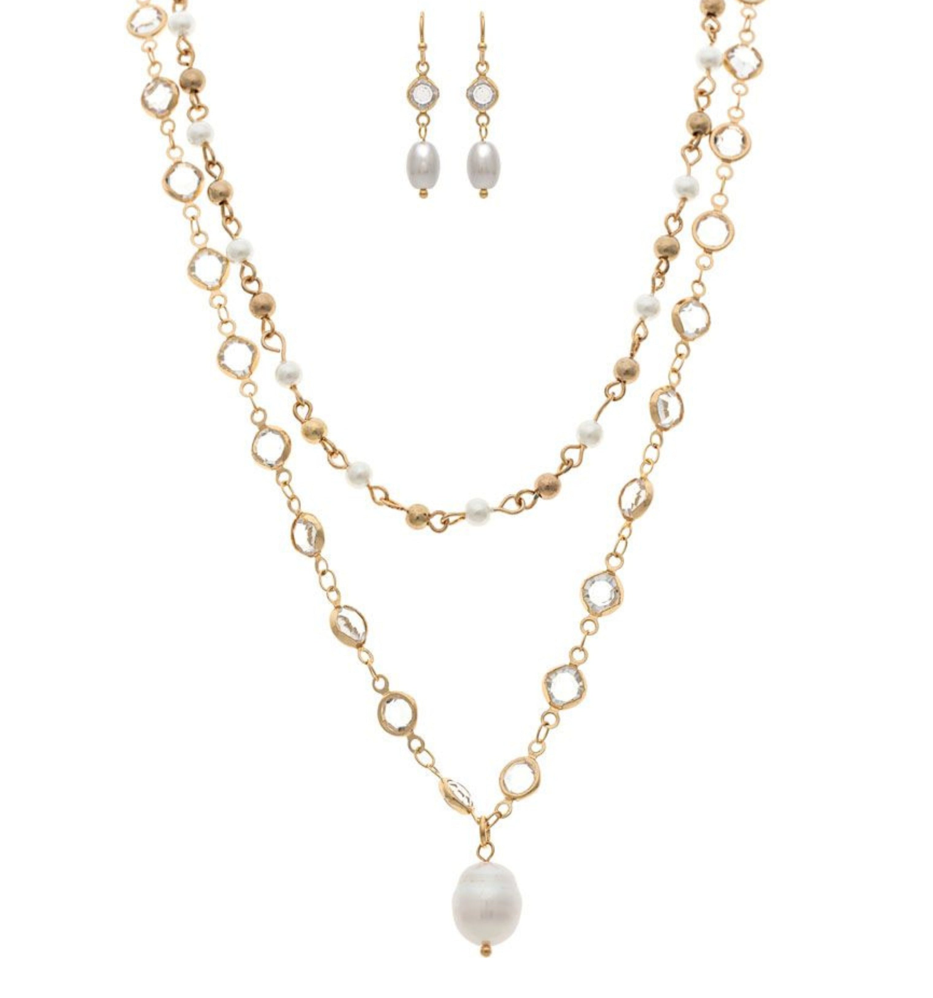 The A-Train Gold Mix Faux Pearl Crystal Necklace Set includes a layered gold-tone necklace with a large pearl pendant and matching drop earrings detailed with white pearls and small crystals.