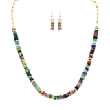 The A-Train Gold Multi Stone Disc Beads Necklace Set features a vibrant necklace with colorful stacked disc beads and gold accents, plus matching dangle earrings with three stacked gold beads for a coordinated style.