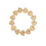 The A-Train Gold Line Etched Hearts Stretch Bracelet features textured gold heart-shaped charms and small beads, crafted from mixed jeweler’s metals for versatile style perfect for any occasion.