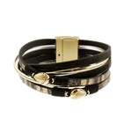 The Origin Black Matte Gold & Gold Teardrop Bead Magnetic Bracelet features multi-layered black bands, gold teardrop beads, and a sleek rectangular gold clasp.