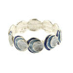 The Origin Silver Layered Blue Circle Bracelet showcases round, layered blue and white discs in a handcrafted, organic design. This versatile jewelry piece suits any occasion with its elegant, repeating pattern.