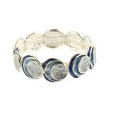 The Origin Silver Layered Blue Circle Bracelet showcases round, layered blue and white discs in a handcrafted, organic design. This versatile jewelry piece suits any occasion with its elegant, repeating pattern.