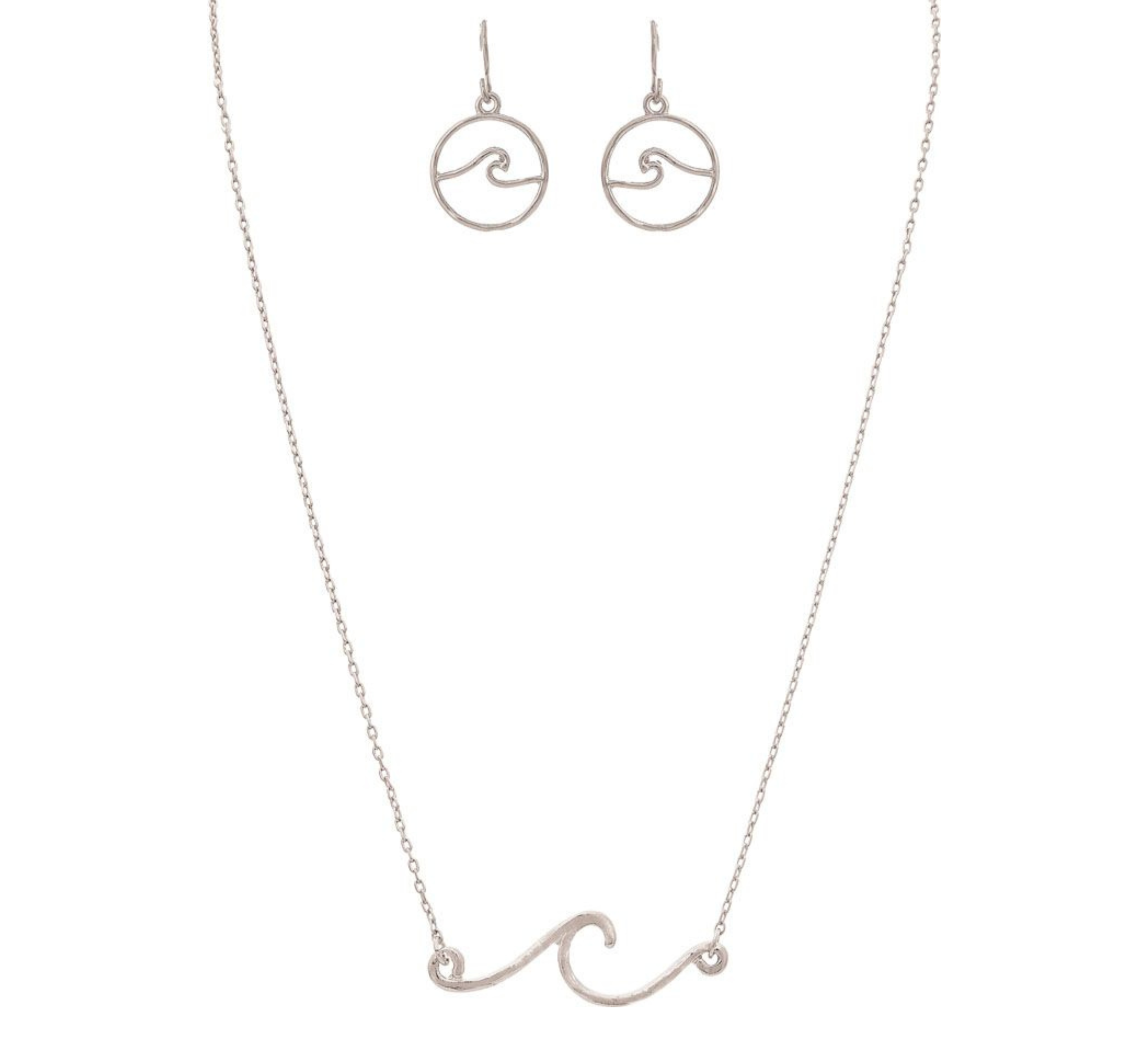 The A-Train Silver Rip Curl Wave Necklace Set includes a delicate necklace with a wave-shaped pendant and matching circular wave earrings, all displayed on a white background.