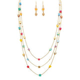 The A-Train Gold Aurora Borealis Coated Multicolor Cube Bead Layer Necklace Set features three layers with red, blue, green, yellow, and pink cube beads and matching gold earrings with small yellow square beads. Displayed on a white background.