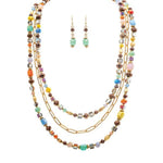 The A-Train Gold Multicolor Faceted Square Beads Layer Necklace Set features high-quality mixed metal craftsmanship and includes matching green beaded dangle earrings for a coordinated look.