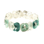 The Origin Matte Silver & Aqua Lily Pad Bracelet features alternating teal and white enamel flower-shaped links with matte silver stamens, arranged in a charming circular pattern for versatile style.