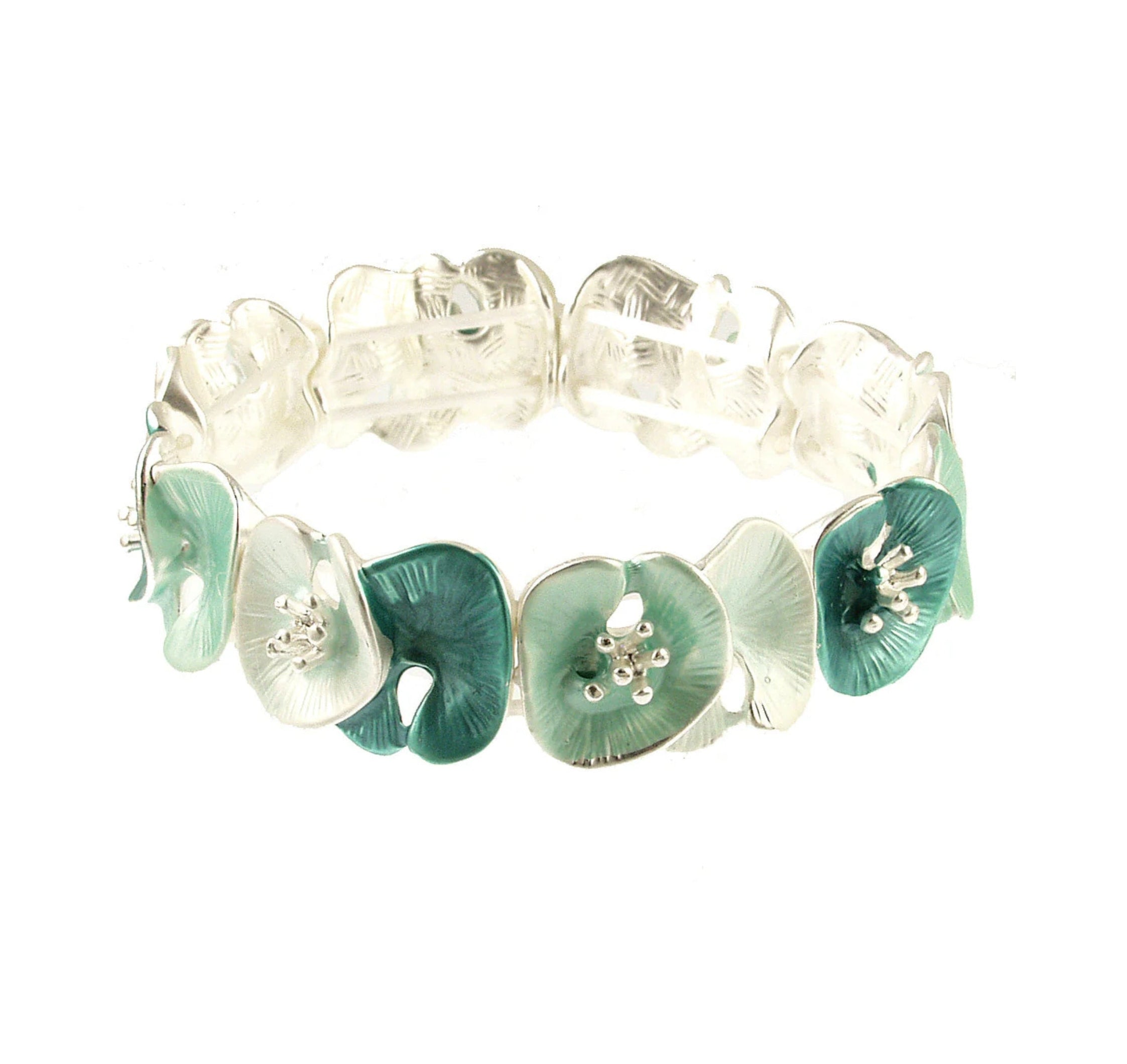 The Origin Matte Silver & Aqua Lily Pad Bracelet features alternating teal and white enamel flower-shaped links with matte silver stamens, arranged in a charming circular pattern for versatile style.