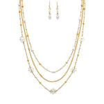 The A-Train Gold White Flowers Beads Chain Layer Necklace Set features a chic necklace and matching drop earrings with delicate chains, pearls, and beads—timelessly styled and perfectly showcased on a plain white background.