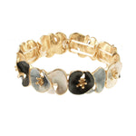 Origins Matte Silver, Gold, White & Gray Lily Pad Bracelet features interconnected, textured flower shapes with raised gold centers—a sophisticated accessory perfect for special occasions.