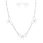 The A-Train Silver Faux Pearl Link Bow Stations Necklace Set features three wire bow designs with small silver faux pearl beads, paired with matching bow-shaped earrings.