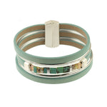 The Origin Matte Silver & Aqua Magnetic Bracelet features three teal leather bands, a silver clasp, and a central row of turquoise glass beads with metallic cube and matte silver accents.