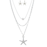The A-Train Silver Freshwater Pearl Layer Chain Starfish Necklace Set features a three-layer necklace with a pearl and starfish pendants, plus matching silver starfish dangle earrings, all displayed on a white background.