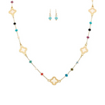 The A-Train Gold Multicolor Bead & Inlay Clovers Necklace Set features a gold necklace with colorful beads and clover charms, paired with matching earrings of turquoise and gold beads, shown on a white background.