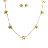 The A-Train Gold Tiny Flower Chain Necklace Set features a necklace with evenly spaced flower charms and matching gold flower stud earrings, crafted from mixed jewelers metals, shown on a white background—perfect for daily chic style.