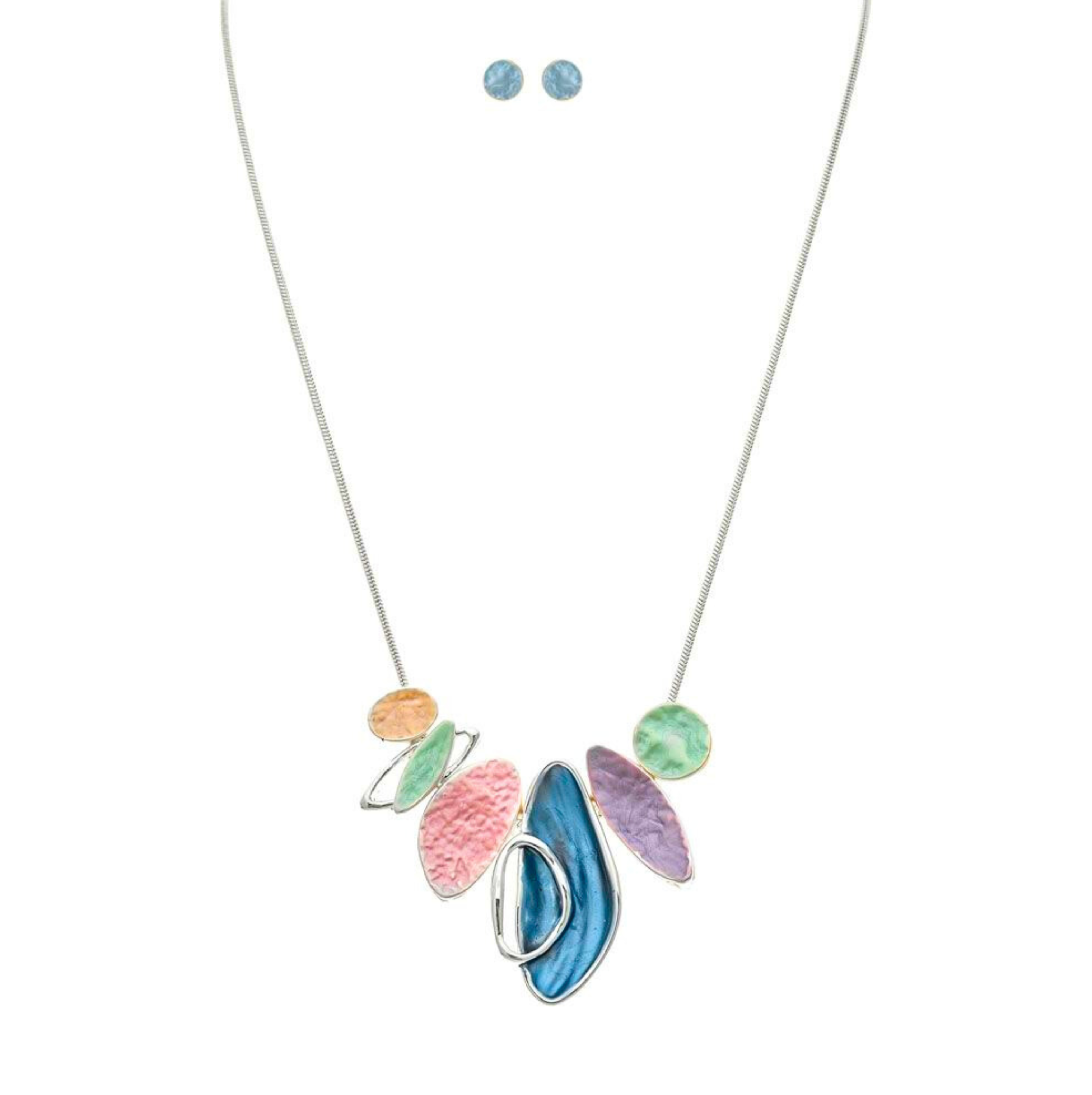 The A-Train Silver Multi-Color Pastel Organic Shapes Necklace Set features a stylish abstract pendant with matching blue stud earrings, crafted from high-quality mixed jeweler’s metals and displayed on a white background.