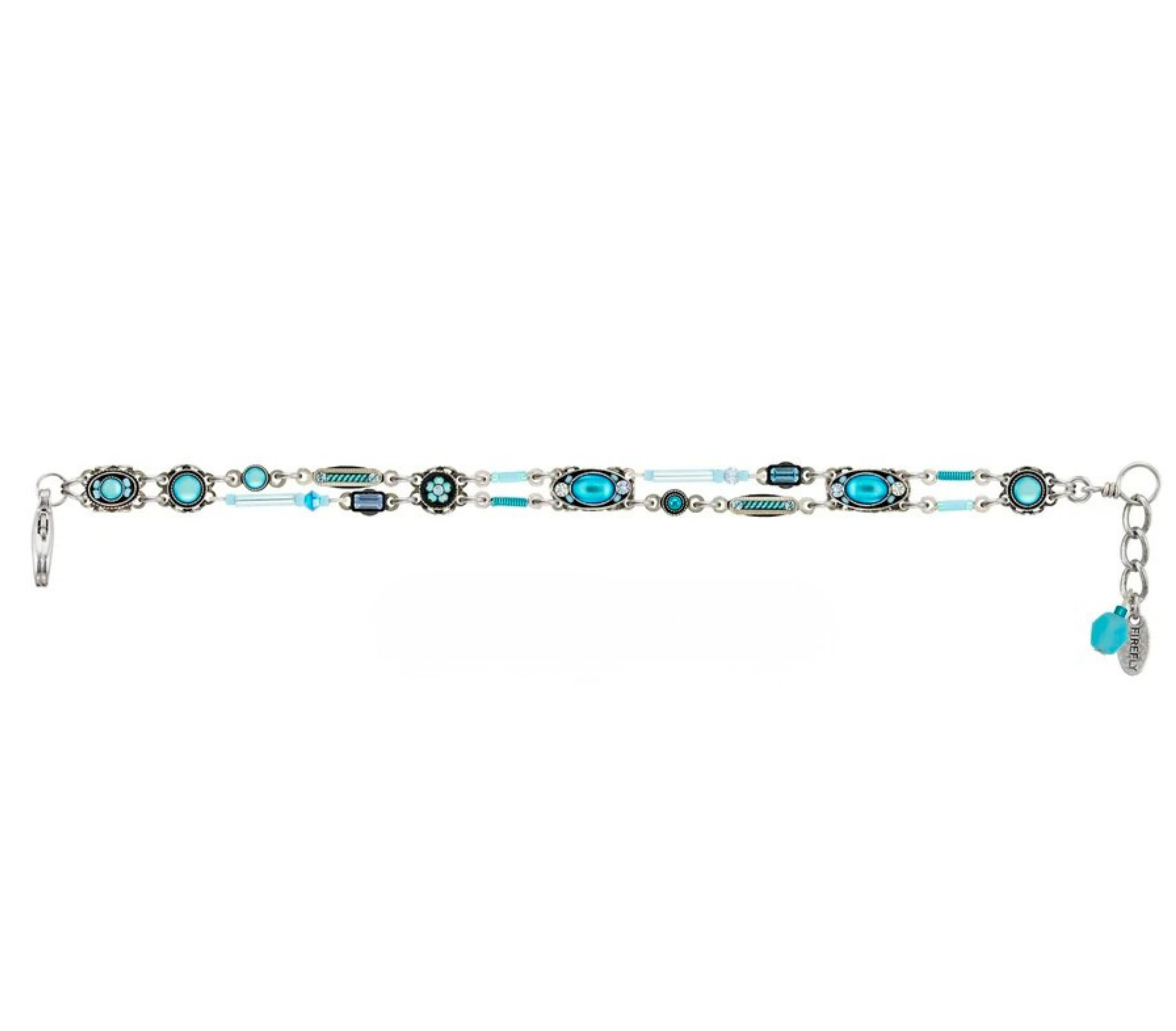The Moonlight Bon Vivant Simple Bracelet Light Blue by Firefly is a stunning fair trade jewelry piece, featuring a handmade silver band adorned with turquoise and blue oval stones, decorative metalwork, small white beads, and a clasp with a blue charm—beautifully blending artisan craftsmanship with elegant design.