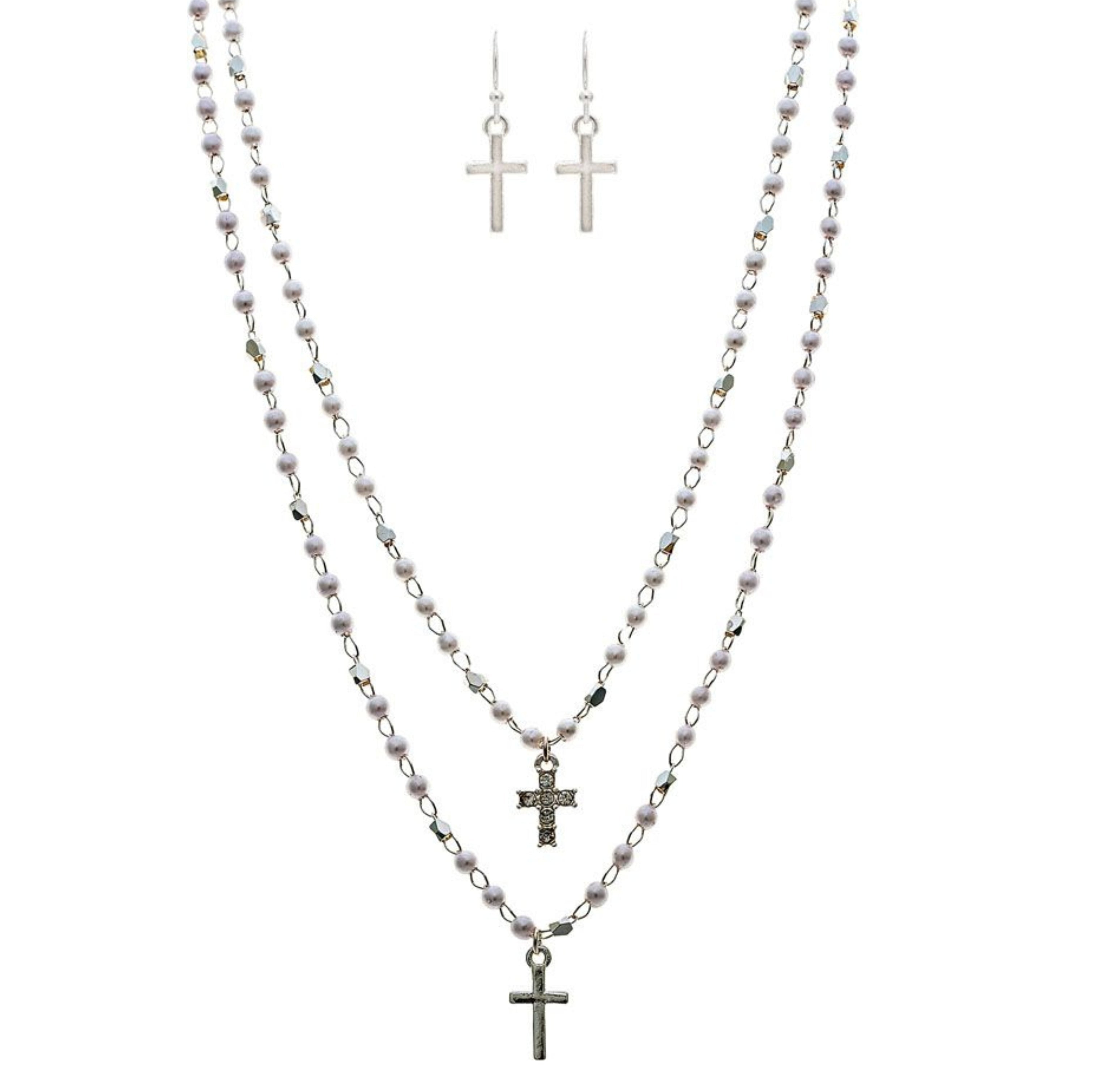 The A-Train Silver Faux Pearl Cross Charm Layered Necklace Set features three silver beaded chain necklaces of varying lengths with cross charms, plus matching drop earrings, all displayed on a white background.